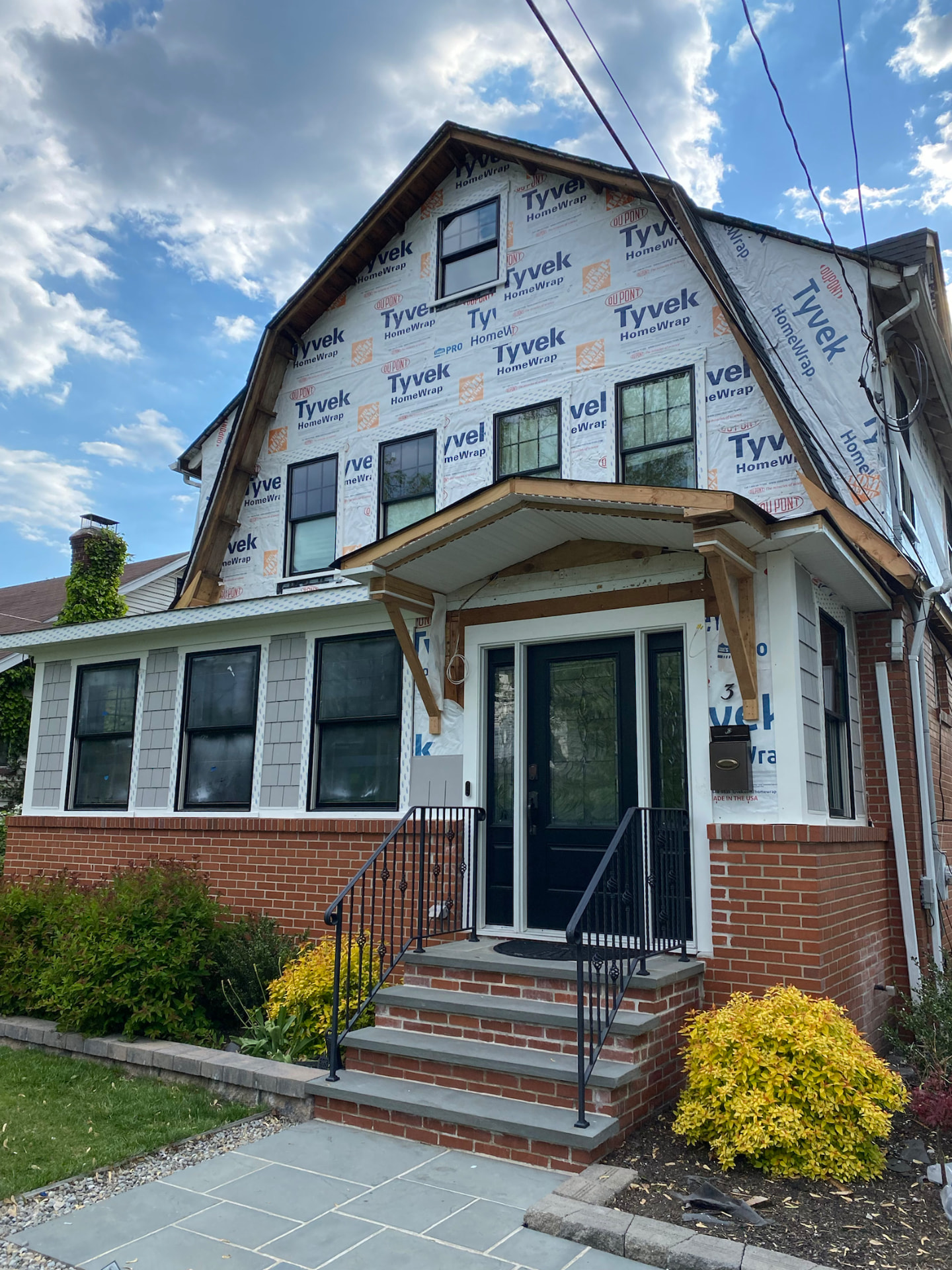Exterior renovation with new front porch and trim carpentry